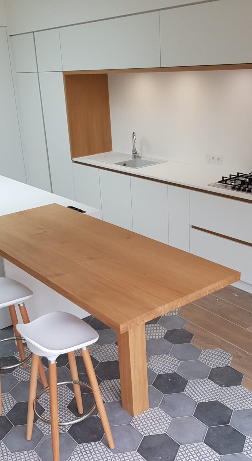 une cuisine avec plan de travail en bois et façades blanches