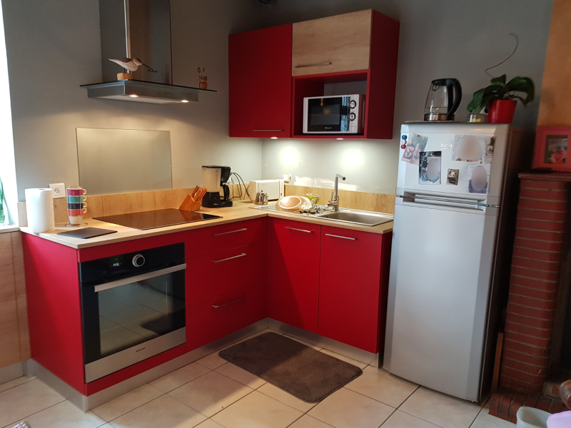 une cuisine bordeaux avec un plan de travail en bois