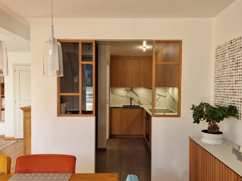 une verrière avec un cadre en bois dans une cuisine blanche